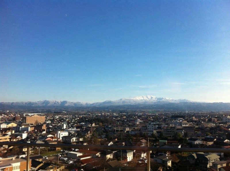 見上げると霊峰月山を望む鶴岡。 